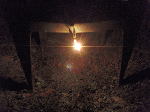 Light bulb on a chair outside, lighting up the yard